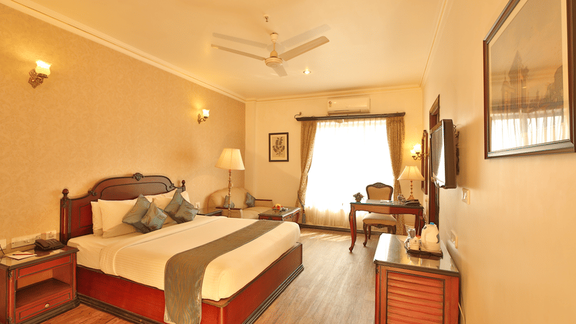 Well-appointed guest room featuring twin beds, wooden flooring, and warm lighting for a comfortable stay at The Lindsay.