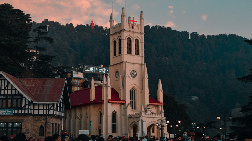 A view of a building in shimla Mall Road with a mountain in the background.