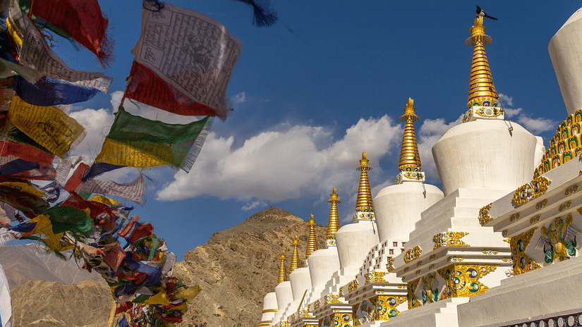 White coloured Buddhist monestry with colourful flags