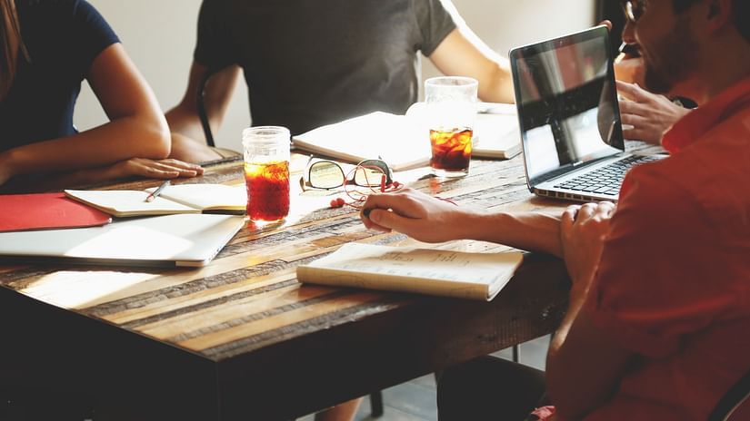 A group of people sitting together brainstorming during a meeting.