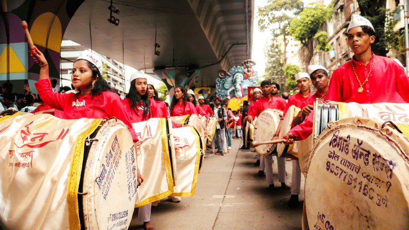 Devotees take part in a vibrant procession, carrying decorated drums through the streets during the celebrations.