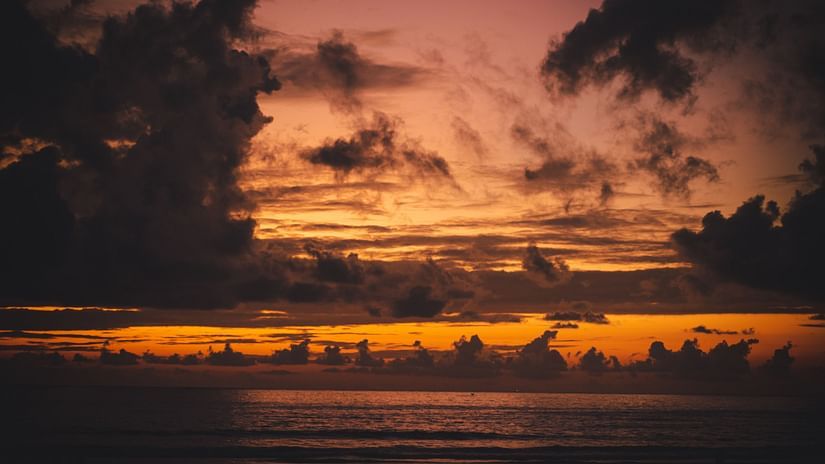 a serene beach in Mumbai with purple clouds