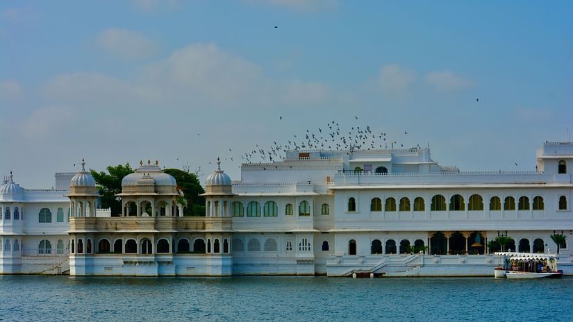 An overview of Lake Palace in Lake Pichola with blue sky in the background.