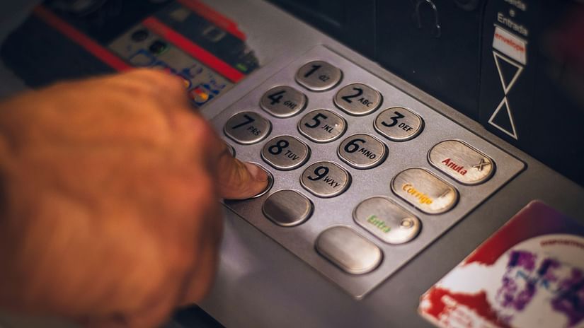 person pressing numbers on an ATM machine