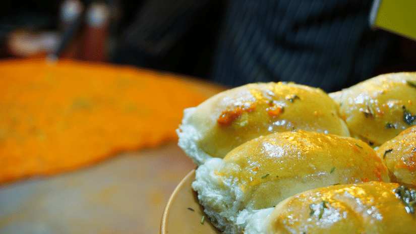Buttered pav buns served alongside traditional street-style accompaniments on a restaurant table
