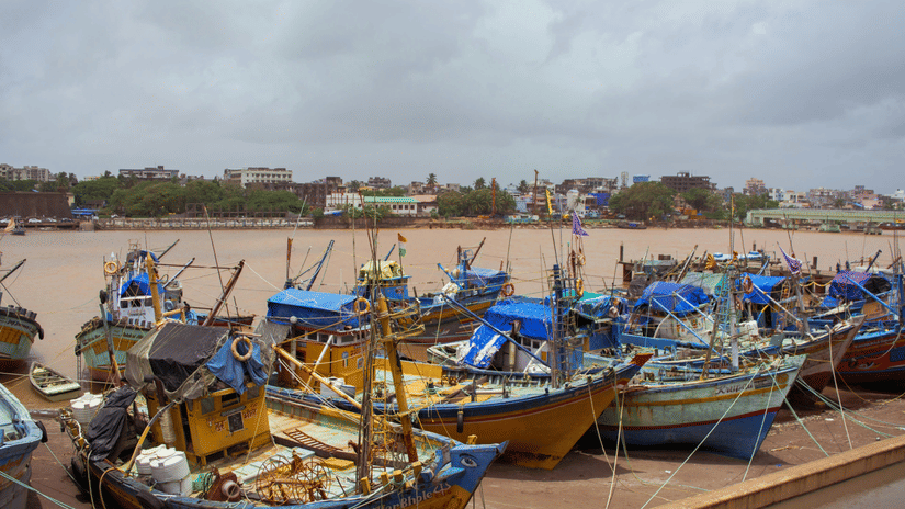 Traditional fishing boats docked at Daman Jetty along the riverfront, showcasing the area's active maritime and fishing culture
