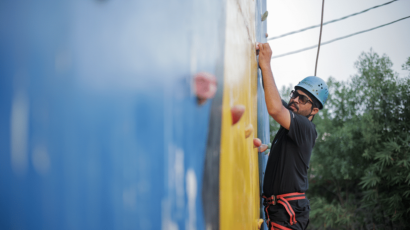 an image of an individual performing rock climbing activity at VITS Roccia Hill Resort & Adventure Park.