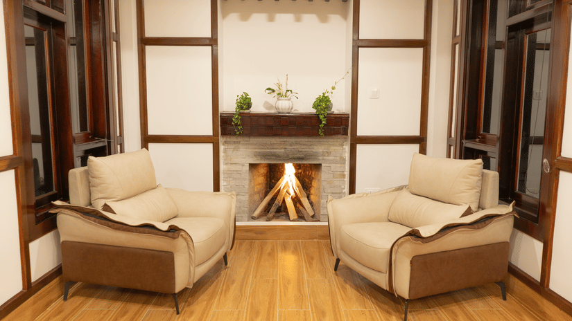 A seating area at Voyage Glenz Resort with sofas, fireplace, and windows.