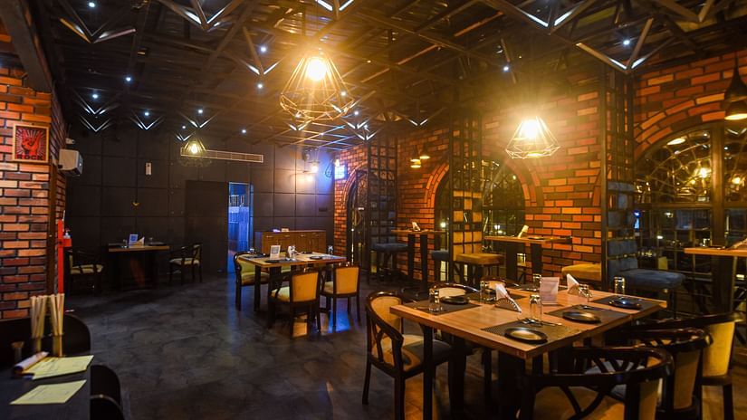 The interiors of TOB has a rustic ambience with bricked walls and mellow lighting - Wedlock Greens Hotel Resorts Dhanbad