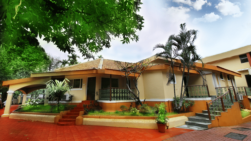 An overview of the exterior facade of the Zara's Resort, Khandala, surrounded by greenery and blue sky in the background.