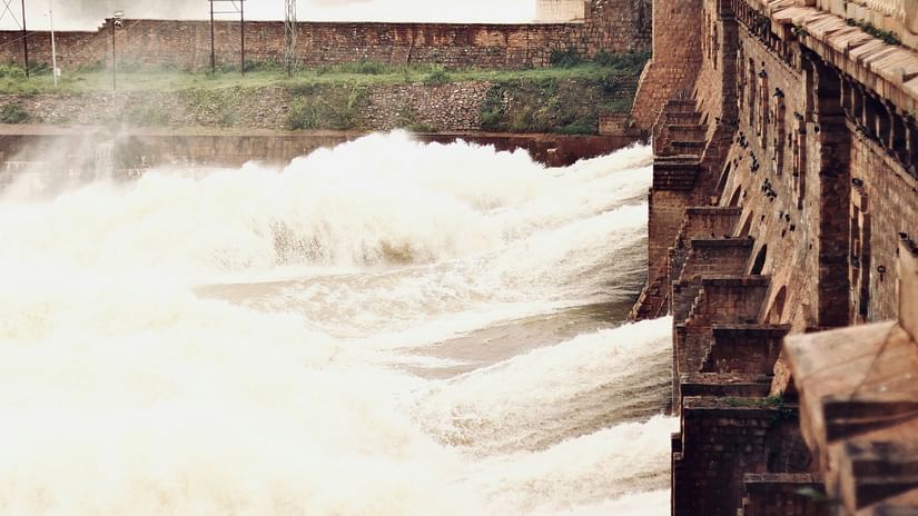 A large dam made of concrete releasing a lot of water. 