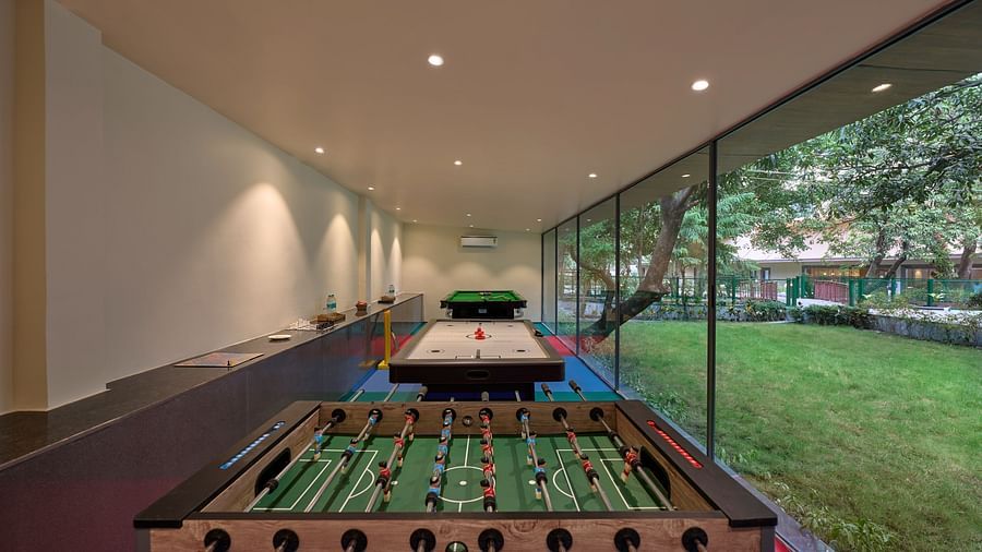 a foosball table, an air hockey table and a pool table in the recreation room at ABN Sarovar Portico, Jim Corbett