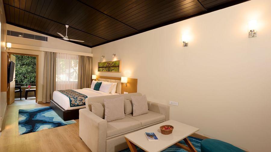 a double bed and sofas in the Cottage at ABN Sarovar Portico, Jim Corbett