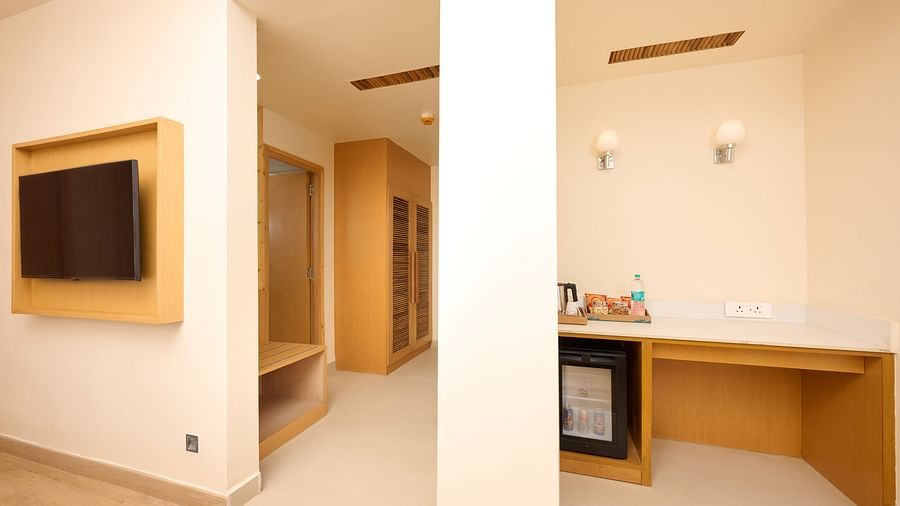 a television, minibar and the closet in the Cottage at ABN Sarovar Portico, Jim Corbett