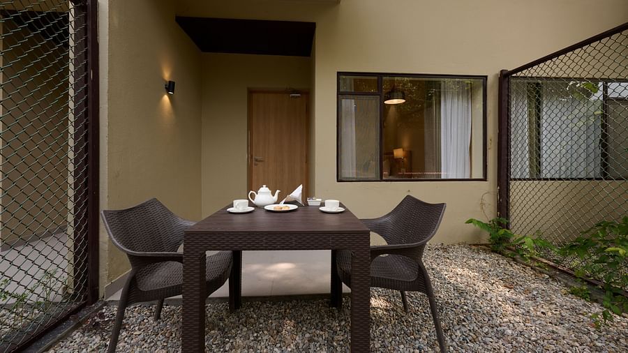 a table and chairs in the Sit-out area of the Deluxe Room at ABN Sarovar Portico, Jim Corbett