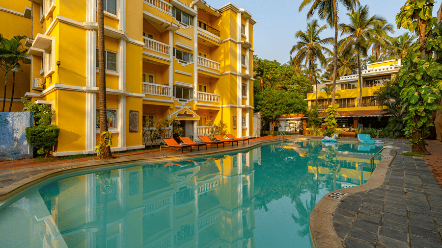 The pool of the hotel surrounded by the hotel building.
