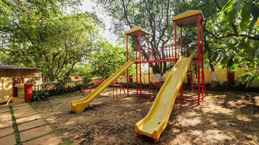 The outdoor kids playing area of Adamo The Village surrounded by greenery.