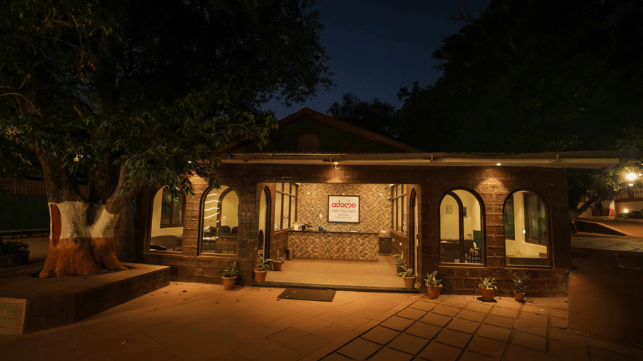 An evening view of a cottage-style structure with a sheltered porch at Adamo The Village