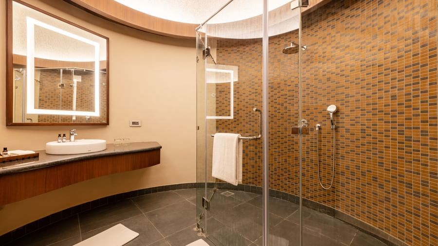 an interior of a bathroom with glass doors, a single faucet and a shower head at Ananta Spa and Resort