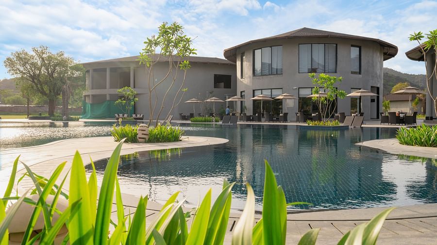 View of a villa at Ananta Spa and Resort, Ajabgarh from the pool under a blue sky