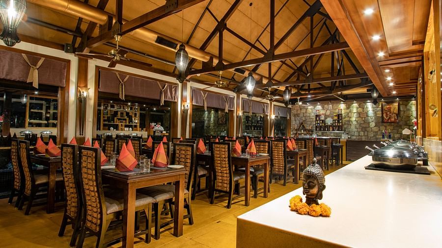 The interiors of Oasis, our multi-cuisine restaurant in Pushkar with tables and chairs and a buffet table 