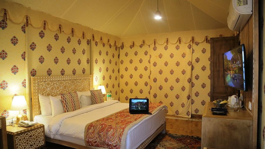 The interiors of our tent suites in Pushkar with a bed, a sofa set and tasteful decor 01