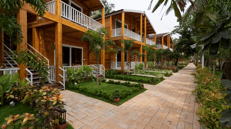 A side facade view of the resort with trees and folliage around-Aralea Beach Resort By Stone Wood, Morjim