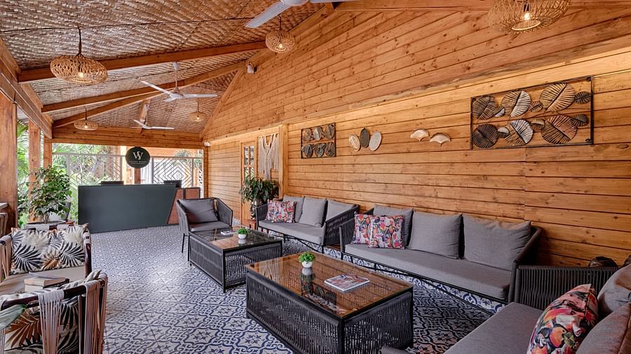 an inner seating area with sofas and table with beams supporting the roof and a patterned tile floor