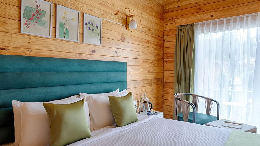 A cozy bedroom with a teal headboard, white bedding, and green accent pillows Aralea Beach Resort by Stone Wood, Morjim