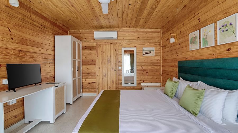 Image of a bedroom from a wider angle, showing the full bed, a white wardrobe, and a TV - Aralea Beach Resort by Stone Wood, Morjim