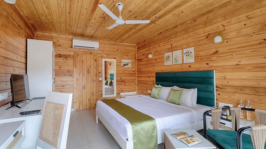 A spacious bedroom with a high wooden ceiling, teal headboard, and green accents, complemented by natural light and modern furnishings - Aralea Beach Resort by Stone Wood, Morjim