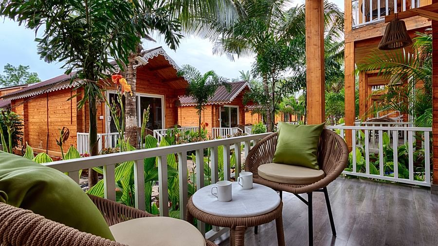 Relaxing resort balcony with wicker chairs, overlooking the cabins Aralea Beach Resort by Stone Wood, Morjim