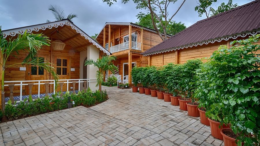 Pathway leading to tropical resort cabins with potted plants and palm trees Aralea Beach Resort by Stone Wood, Morjim