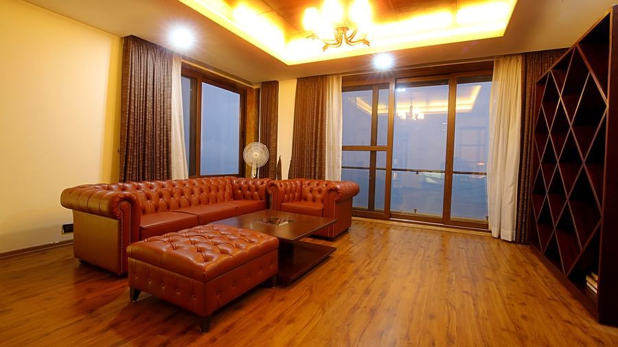 well lit sitting area with brown sofa - Aranya Himalayan Retreat, Mashobra
