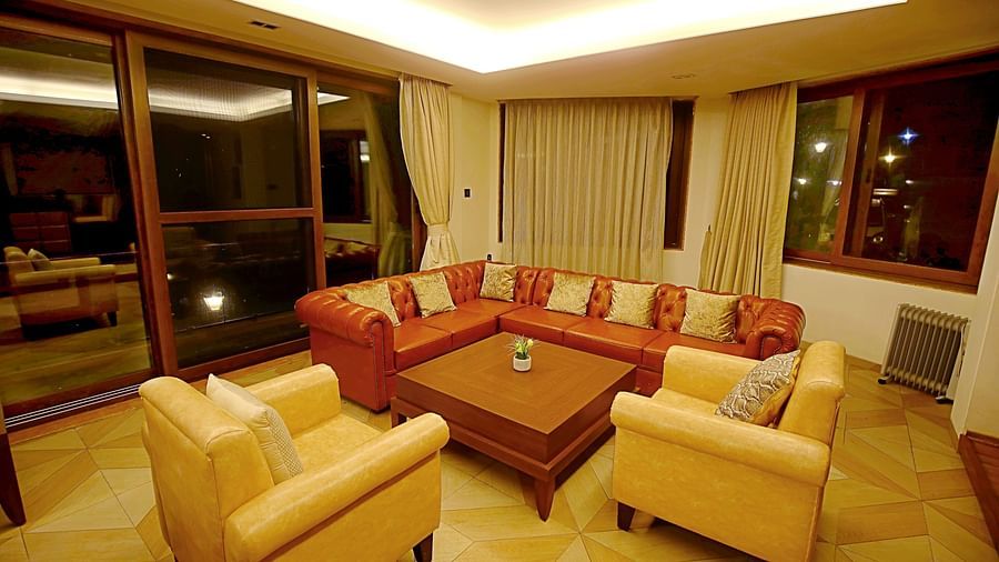 warmly lit living room with centre table - Aranya Himalayan Retreat, Mashobra