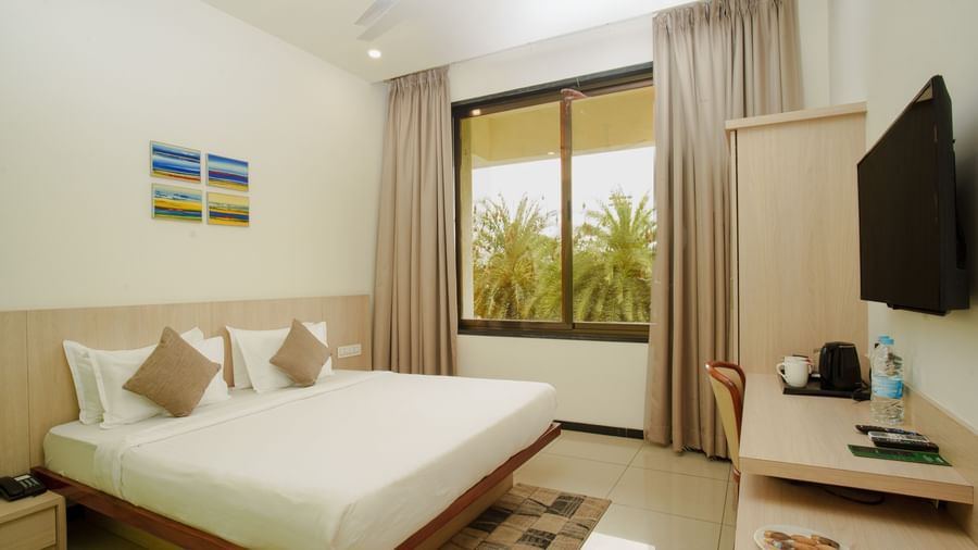Hotel room featuring a large bed, wall-mounted television, and a window with natural light at Arawali Ananta Elite, Jaipur.