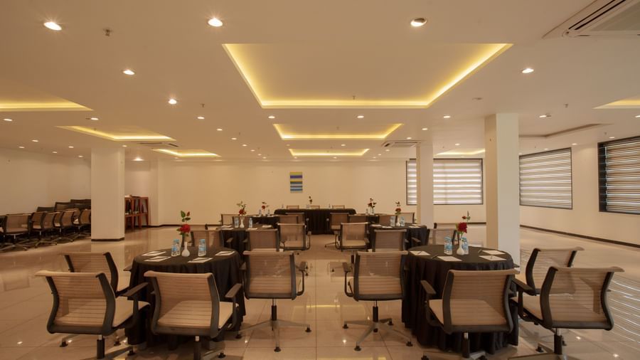 Spacious conference hall with multiple tables and ergonomic chairs set up for a workshop or event at Arawali Ananta Elite, Jaipur.