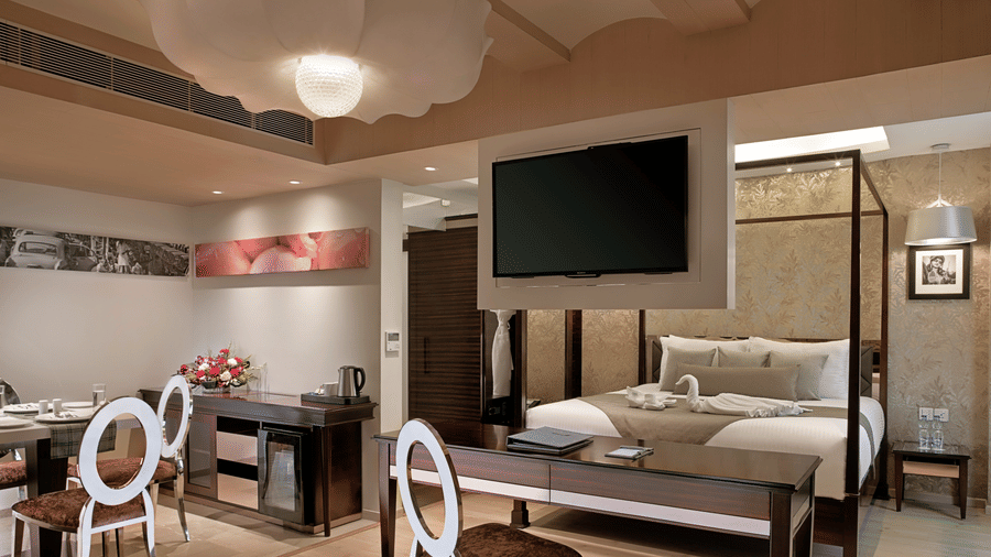 An intricately designed Suite at Barsana Boutique Hotel, Kolkata, featuring a spacious bed, dining space and a work desk.