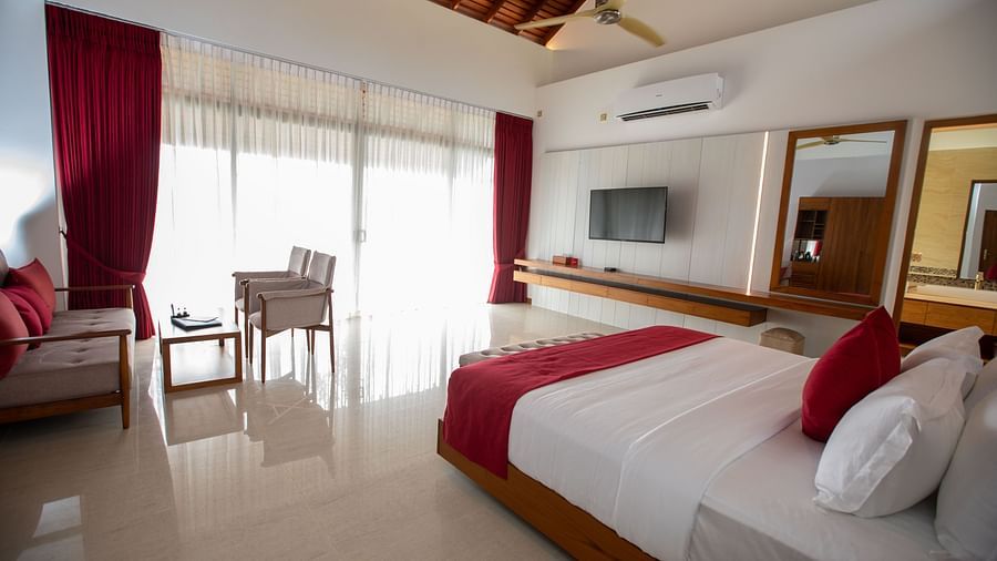 side angle view of the sea view superior rooms at the beacon by the bay villas and suites at dondra featuring ahuge french windows in front of the bed