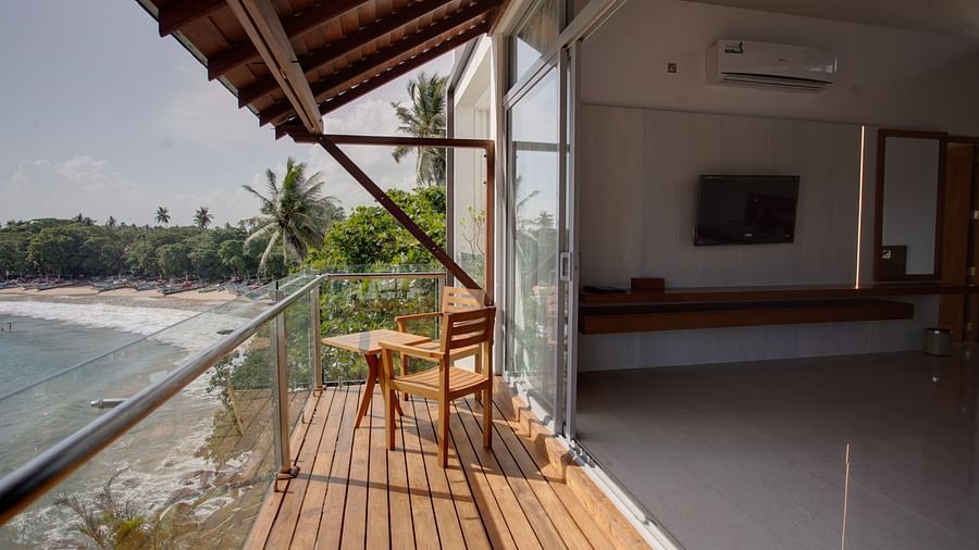 a bright image of the balcony of the sea view superior suite with hard wood flooring overseeing a beautiful sea view