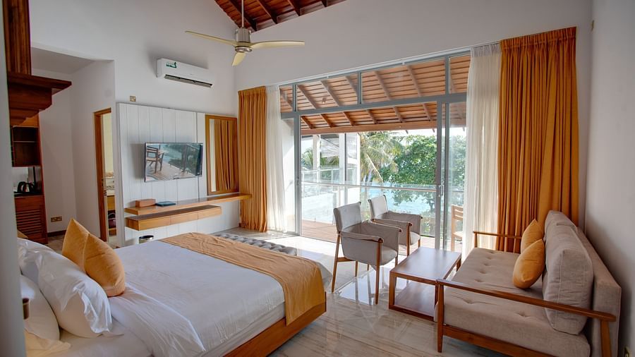 image of a cosy sea view suite room featuring a king size bed and a common seating area 