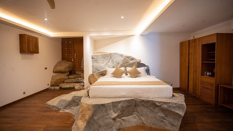 image of the sea view rock suite featuring a king size bed installed upon a huge rock with steps on it