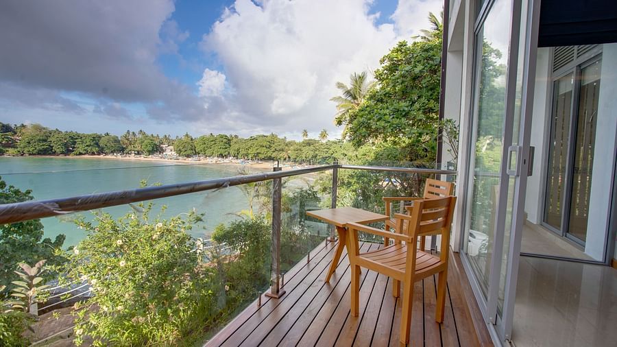 image of an extensive balcony with a ceylon teak wood chair overseeing a beautiful ocean view from the balcony