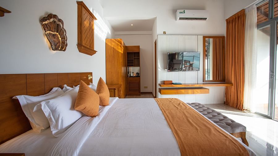 image of the sea view suite featuring a king sized bed with a wall mounted television 