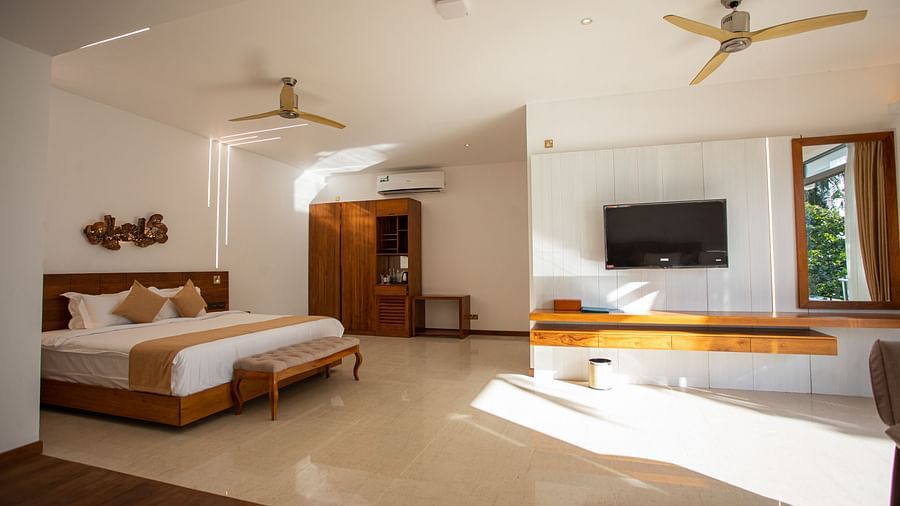 image of the sea view suite featuring a wall mounted television along with a king size bed with subtle modern interiors