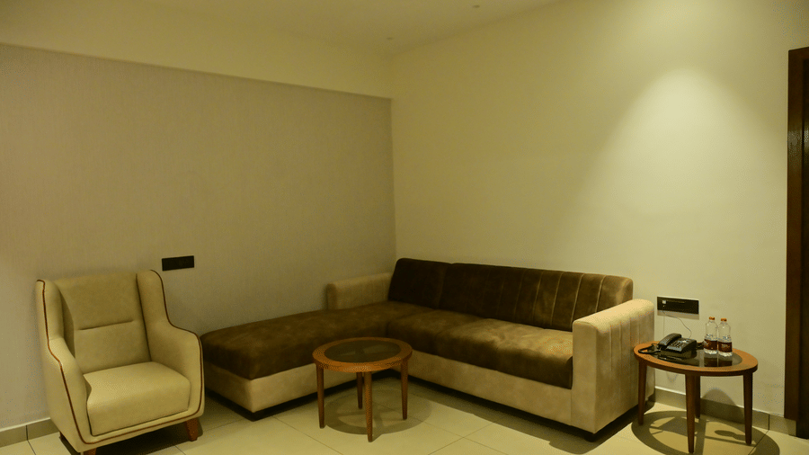 Lounge area of Bhavanis Vista By Icon featuring an armchair, a sofa, and a coffee table.