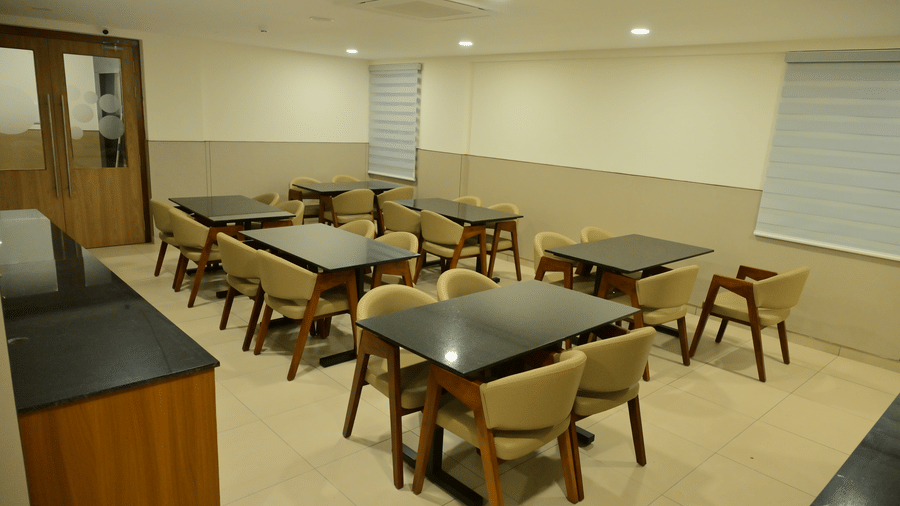 Banquet hall of Bhavanis Vista By Icon featuring tables and chairs arranged for seating.