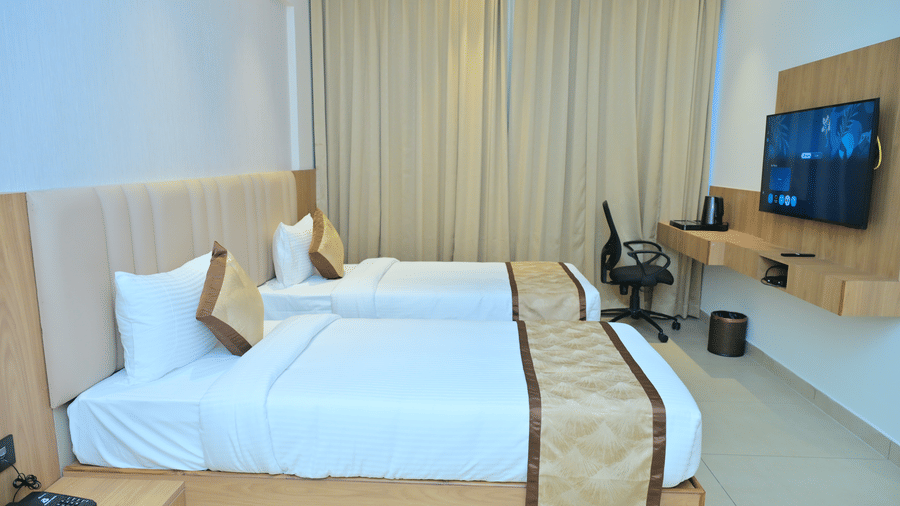 Bedroom of Bhavanis Vista By Icon featuring a bed, a headboard, a desk, and a television.