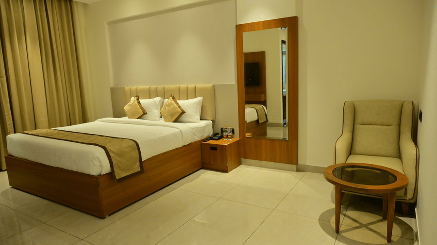 Bedroom of Bhavanis Vista By Icon featuring a bed, a headboard, an armchair, and a mirror.