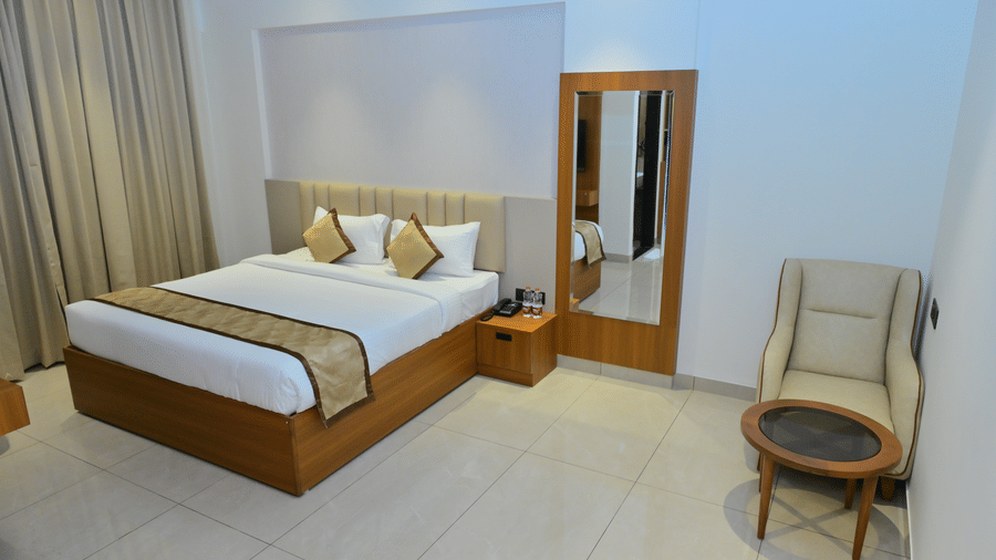 Bedroom of Bhavanis Vista By Icon featuring a bed, a headboard, a mirror, and a chair.